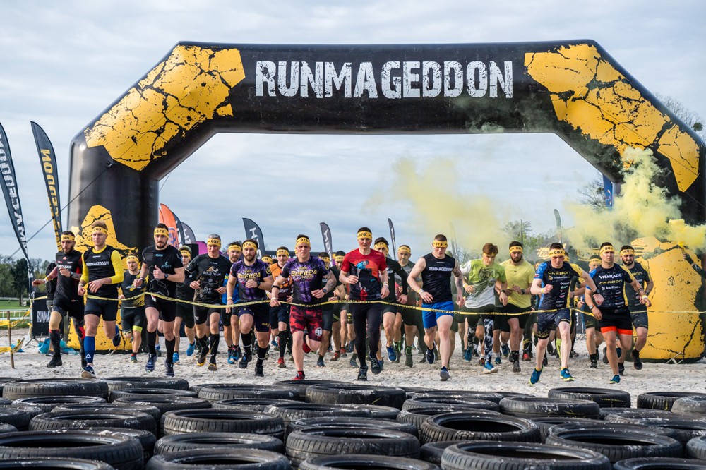 Zdjęcie przedstawia uczestników Runmageddonu - imprezy biegowej z przeszkodami podczas rywalizacji