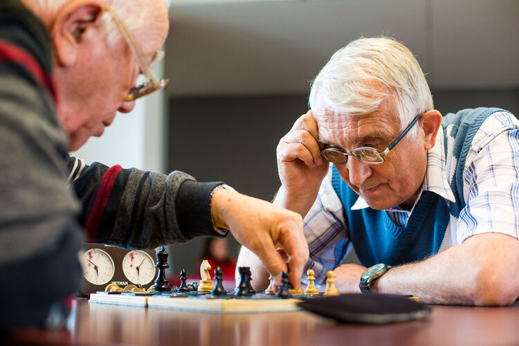 Seniorzy przy partii szachów