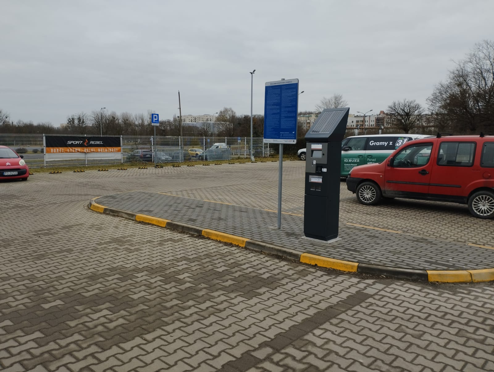 Parking przed Lodowiskiem Chwiałka - Na parkingu widać automat parkingowy i zaparkowane samochody