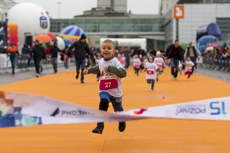 chłopiec wbiega na metę Phoenix Kids Półmaratonu