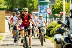za zdjęciu widać rowerzystów przejeżdżających przez bramę.